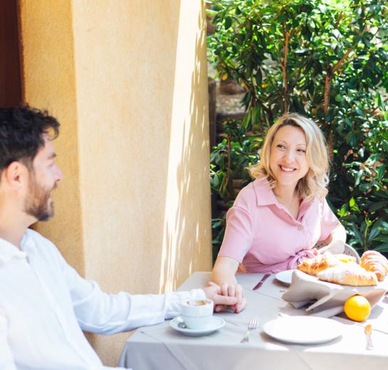 Coppia felice a colazione con frutta e dolci.